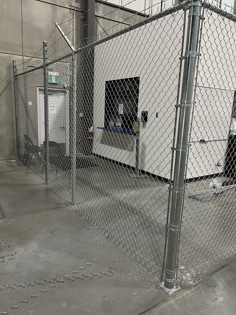 Indoor chain link fence with barbed wire