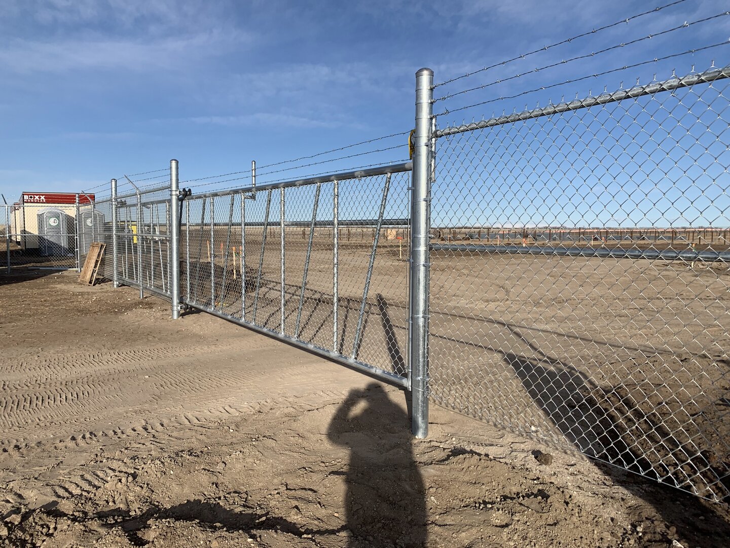 Commercial chain link fence with cantilever gate and barbed wire