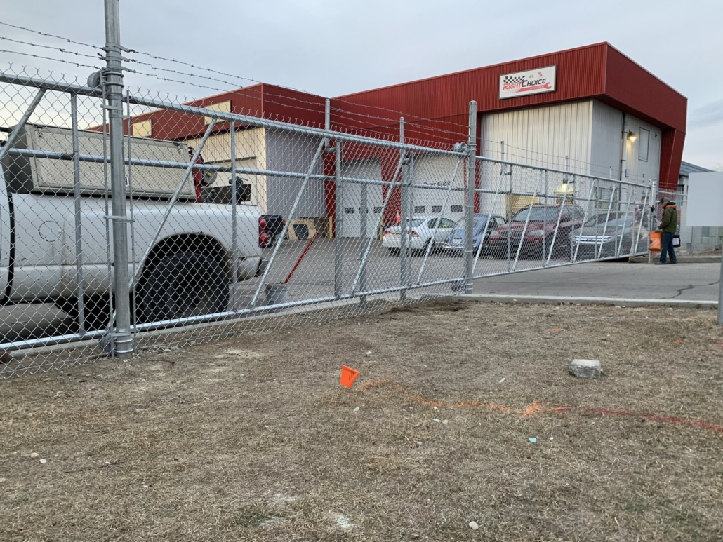 Commercial chain link fence with barbed wire and cantilever gate